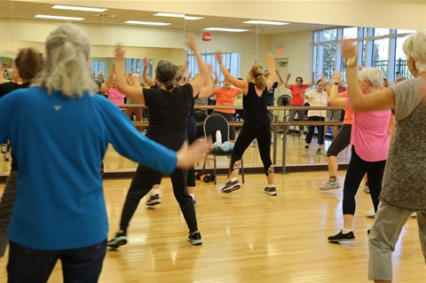 People dancing in dance room in front of mirror